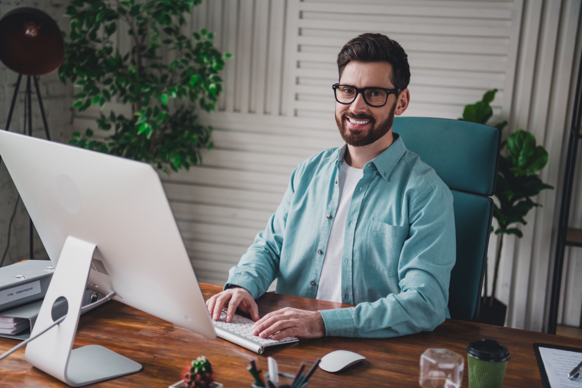 En mann sitter for seg selv på et kontor foran en PC og jobber i stillhet. For å symbolisere et introvert menneske